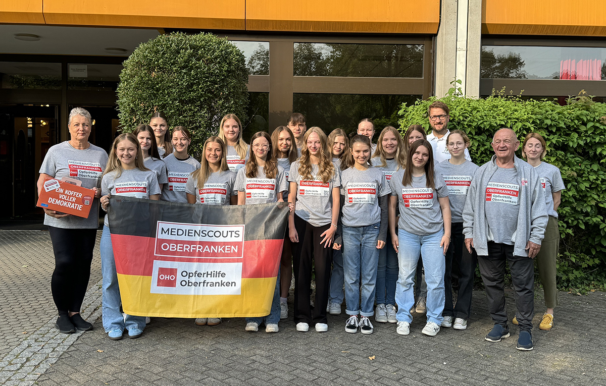 Auf dem Bild sind Susanne Werner, Matthias Schneider Alfons Hrubesch, Christina Herrmann und die Medienscouts des Frankenwaldgymnasiums mit ihren neuen T-Shirts zu sehen.